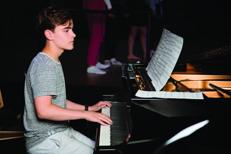 Pianoa nuoteista soittava teini-ikäinen poika.