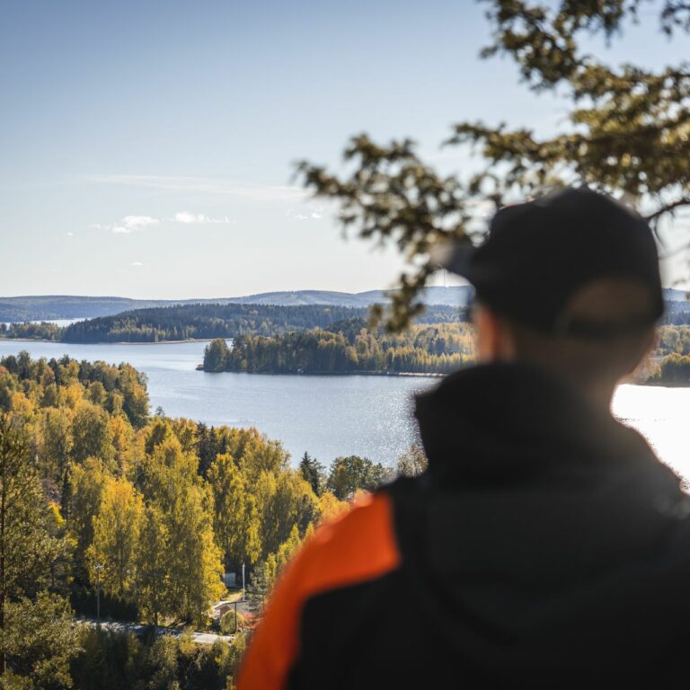 henkilö katsoo edessä avautuvaa järvimaisemaa
