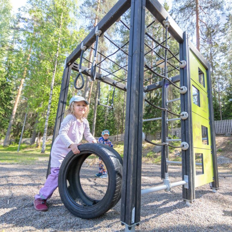 Lapset leikkivät kiipeilytelineessä.