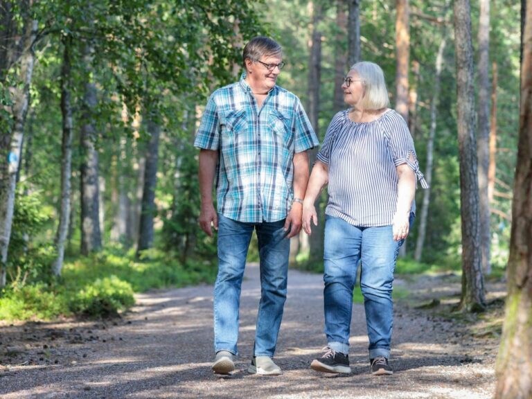 Senioripariskunta kävelee hiekkapolkua.